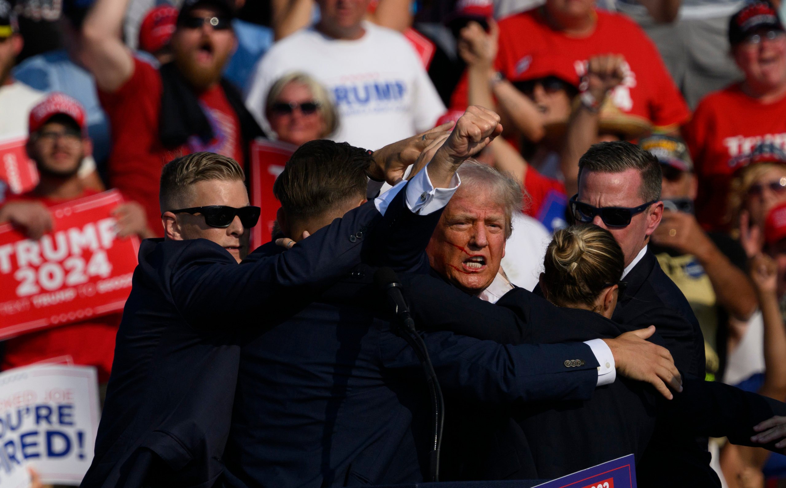 BUTLER, PENNSYLVANIA - JULY 13: Republican presidential candidate, former U.S. President Donald Trump is whisked away by Secret Service after shots rang out at a campaign rally at Butler Farm Show Inc. on July 13, 2024 in Butler, Pennsylvania. Trump slumped and injuries were visible to the side of his head. Butler County district attorney Richard Goldinger said the shooter and one audience member are dead and another was injured. (Photo by Jeff Swensen/Getty Images)