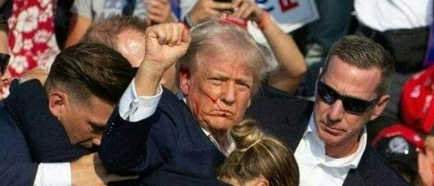 Republican candidate Donald Trump is seen with blood on his face surrounded by secret service agents as he is taken off the stage at a campaign event at Butler Farm Show Inc. in Butler, Pennsylvania, July 13, 2024. Republican candidate Donald Trump was evacuated from the stage at today's rally after what sounded like shots rang out at the event in Pennsylvania, according to AFP. The former US president was seen with blood on his right ear as he was surrounded by security agents, who hustled him off the stage as he pumped his first to the crowd. Trump was bundled into an SUV and driven away. (Photo by Rebecca DROKE / AFP) (Photo by REBECCA DROKE/AFP via Getty Images)