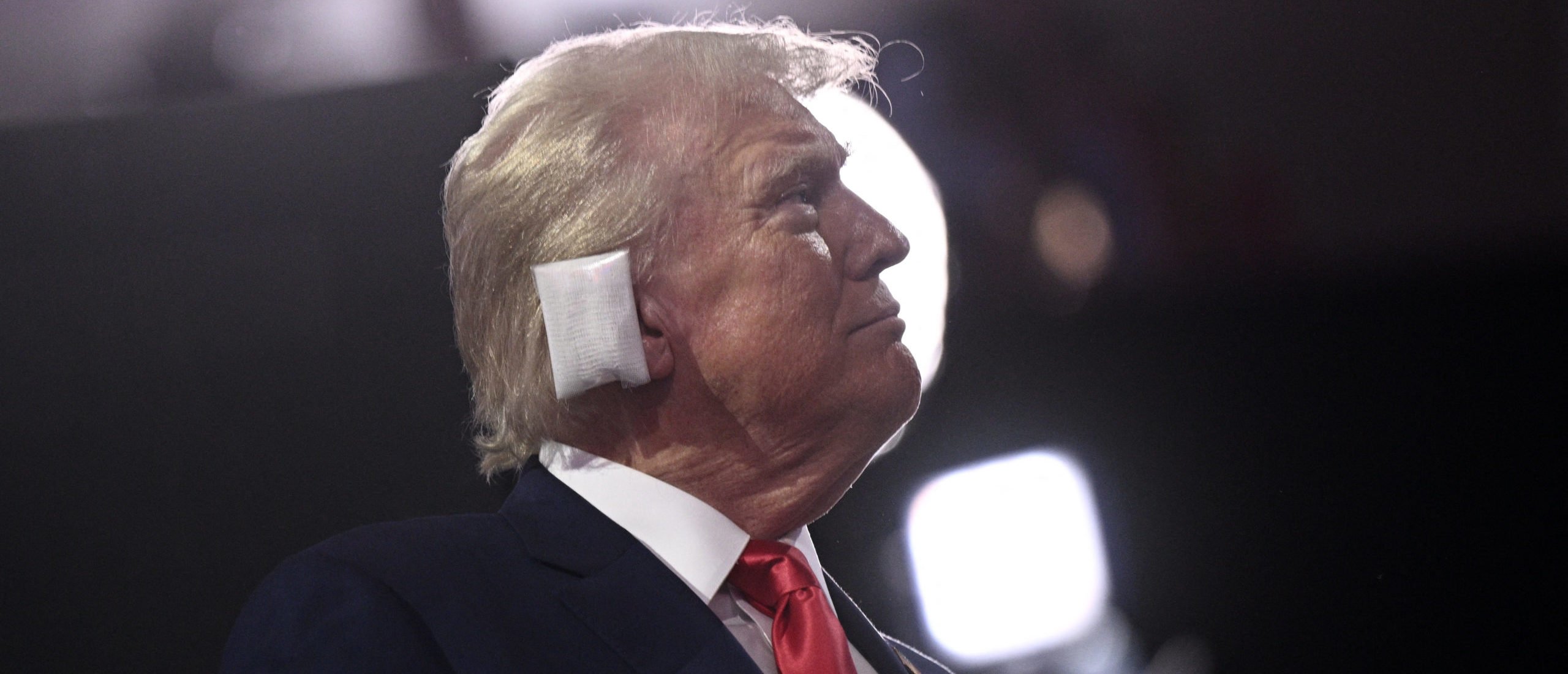 TOPSHOT - US former President and 2024 Republican presidential candidate Donald Trump, a bandage on his ear after being wounded in an assassination attempt, looks on during the first day of the 2024 Republican National Convention at the Fiserv Forum in Milwaukee, Wisconsin, July 15, 2024. Donald Trump won formal nomination as the Republican presidential candidate and picked a right-wing loyalist for running mate, kicking off a triumphalist party convention in the wake of last weekend's failed assassination attempt. (Photo by Brendan SMIALOWSKI / AFP) (Photo by BRENDAN SMIALOWSKI/AFP via Getty Images)