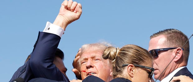 Republican presidential candidate former President Donald Trump is rushed offstage by U.S. Secret Service agents after being grazed by a bullet during a rally on July 13, 2024 in Butler, Pennsylvania. (Photo by Anna Moneymaker/Getty Images)