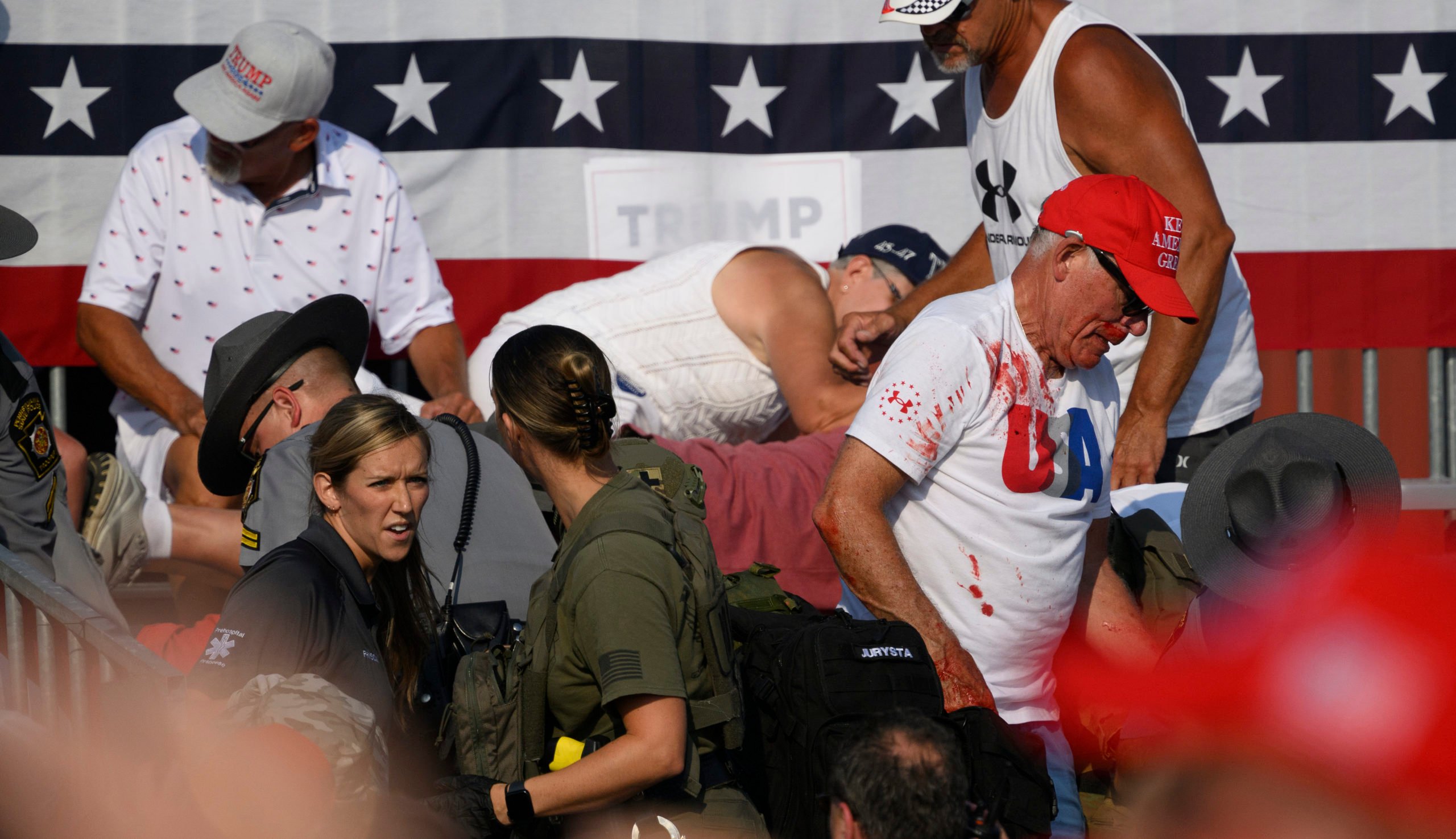 Audience members duck in the crowd during a shooting attempt at a campaign rally for Republican presidential candidate, former U.S. President Donald Trump at Butler Farm Show Inc. on July 13, 2024 in Butler, Pennsylvania. (Photo by Jeff Swensen/Getty Images)