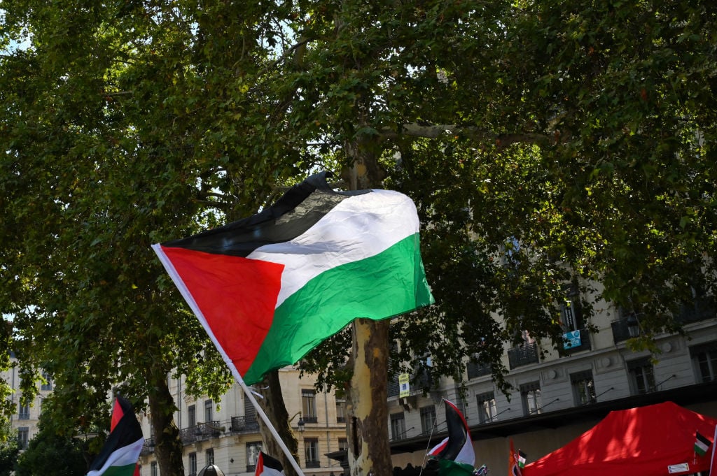 A Palestine flag flies in the air during a gathering in support of the Palestinian people and in opposition to the Paris 2024 Olympic Games, in Lyon, France, July 27, 2024. (Photo by Matthieu Delaty / Hans Lucas / Hans Lucas via AFP) (Photo by MATTHIEU DELATY/Hans Lucas/AFP via Getty Images)