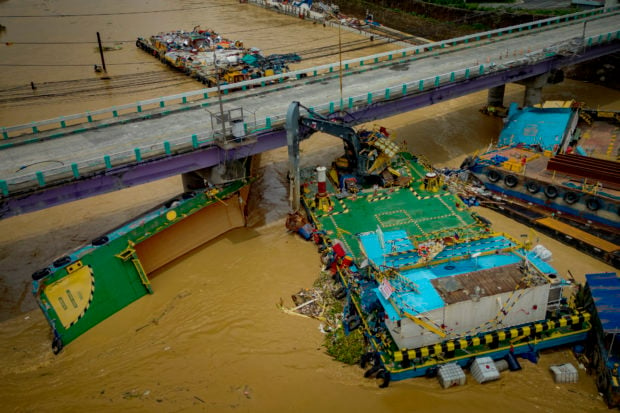 MANILA, PHILIPPINES - JULY 25: In an aerial view, barges that crashed into a bridge during the onslaught of Typhoon Gaemi are seen on July 25, 2024 in Pasig, Metro Manila, Philippines. Monsoon rains, intensified by Typhoon Gaemi, have caused flooding and landslides throughout the Philippines, resulting in at least 22 deaths and displacing over 600,000 people. The typhoon, which also left two dead in Taiwan, did not make landfall in the Philippines but enhanced monsoon rains. In the region around the capital Manila, government work and schools were suspended due to severe overnight flooding. (Photo by Ezra Acayan/Getty Images)