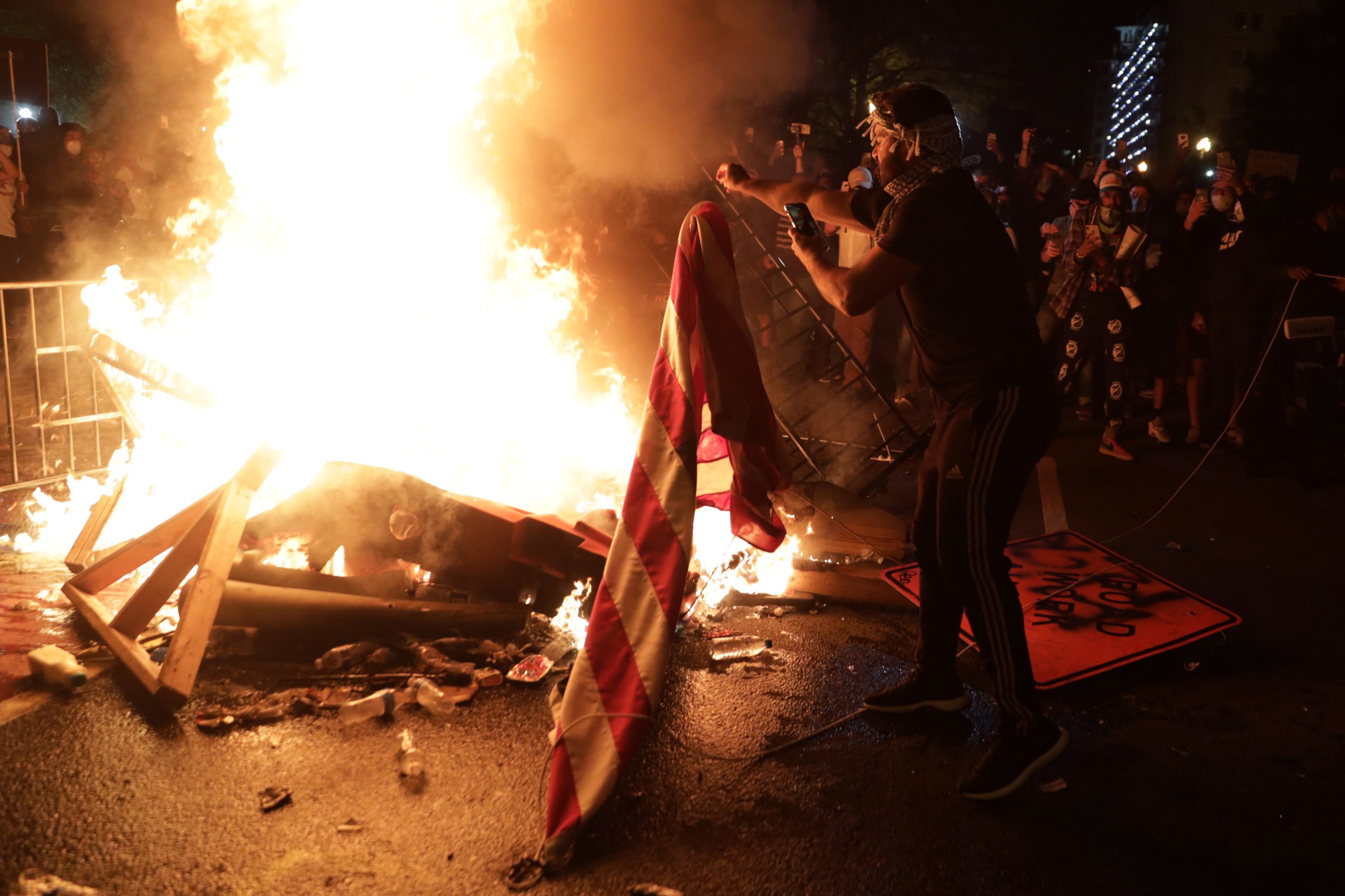 WASHINGTON, DC - MAY 31: Demonstrators set a fire and burn a U.S. flag during a protest near the White House on May 31, 2020 in Washington, DC. Minneapolis police officer Derek Chauvin was arrested for Floyd's death and is accused of kneeling on Floyd's neck as he pleaded with him about not being able to breathe. Floyd was pronounced dead a short while later. Chauvin and three other officers, who were involved in the arrest. Alex Wong/Getty Images