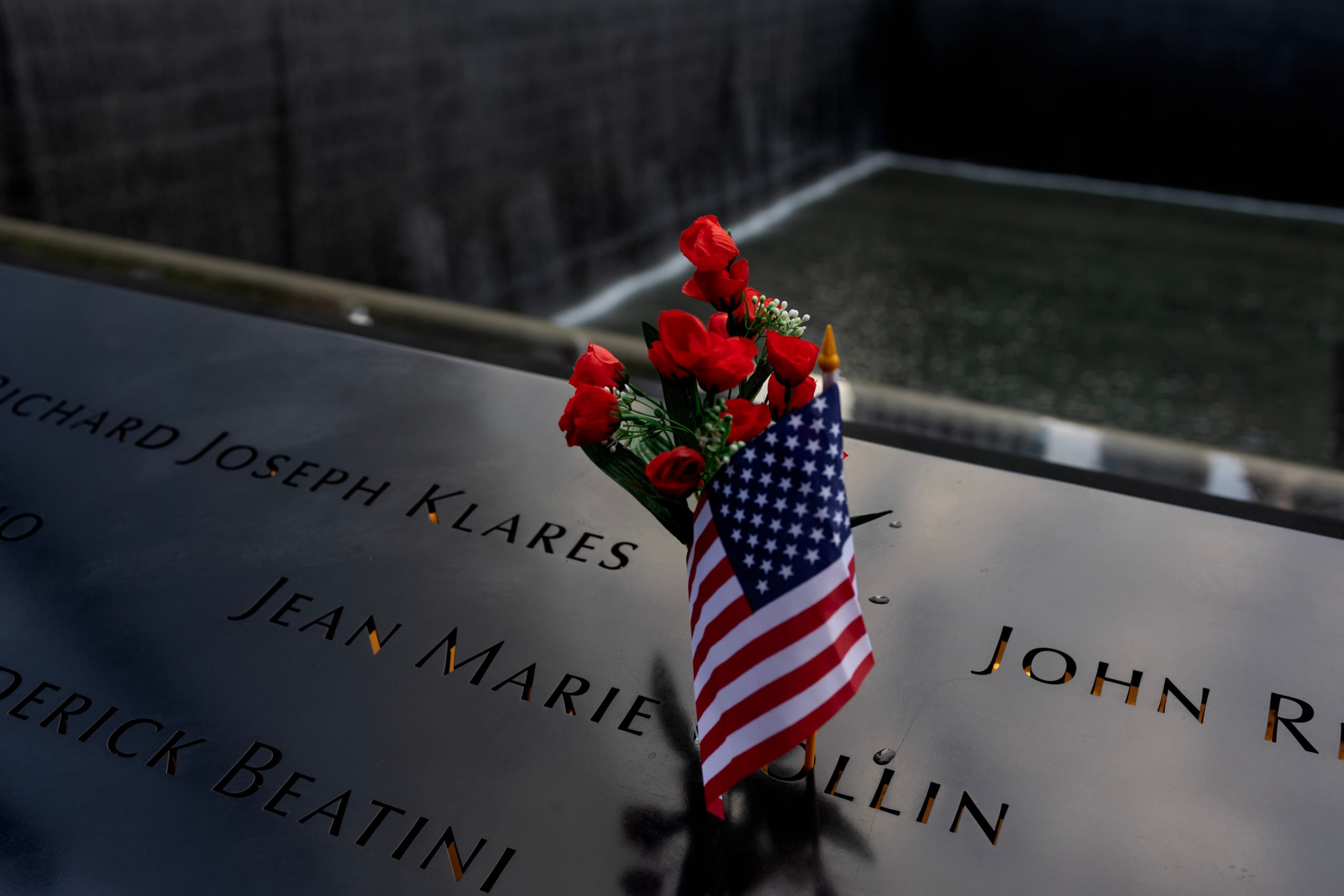 On the evening before the annual September 11 memorial services, people leave flowers and mementos in memory of the dead, September 10, 2023, at the Ground Zero World Trade Center memorial site. (Photo by Andrew Lichtenstein/Corbis via Getty Images)