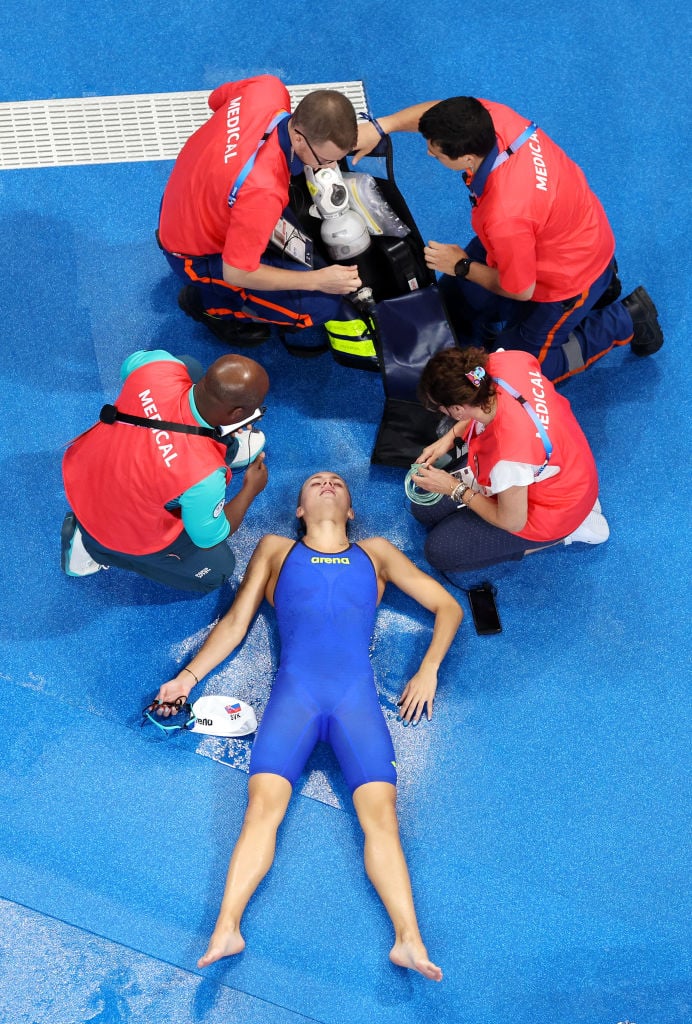 NANTERRE, FRANCE - AUGUST 02: (EDITORS NOTE: Image was captured using a robotic camera positioned above the field of play.) Tamara Potocka of Team Slovakia receives medical treatment after collapsing following the Women's 200m Individual Medley Heats on day seven of the Olympic Games Paris 2024 at Paris La Defense Arena on August 02, 2024 in Nanterre, France. (Photo by Al Bello/Getty Images)