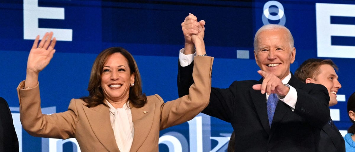 TOPSHOT - US President Joe Biden holds US Vice President and 2024 Democratic presidential candidate Kamala Harris hand after delivering the keynote address on the first day of the Democratic National Convention (DNC) at the United Center in Chicago, Illinois, on August 19, 2024. Vice President Kamala Harris will formally accept the party's nomination for president at the DNC which runs from August 19-22 in Chicago. (Photo by ROBYN BECK/AFP via Getty Images)