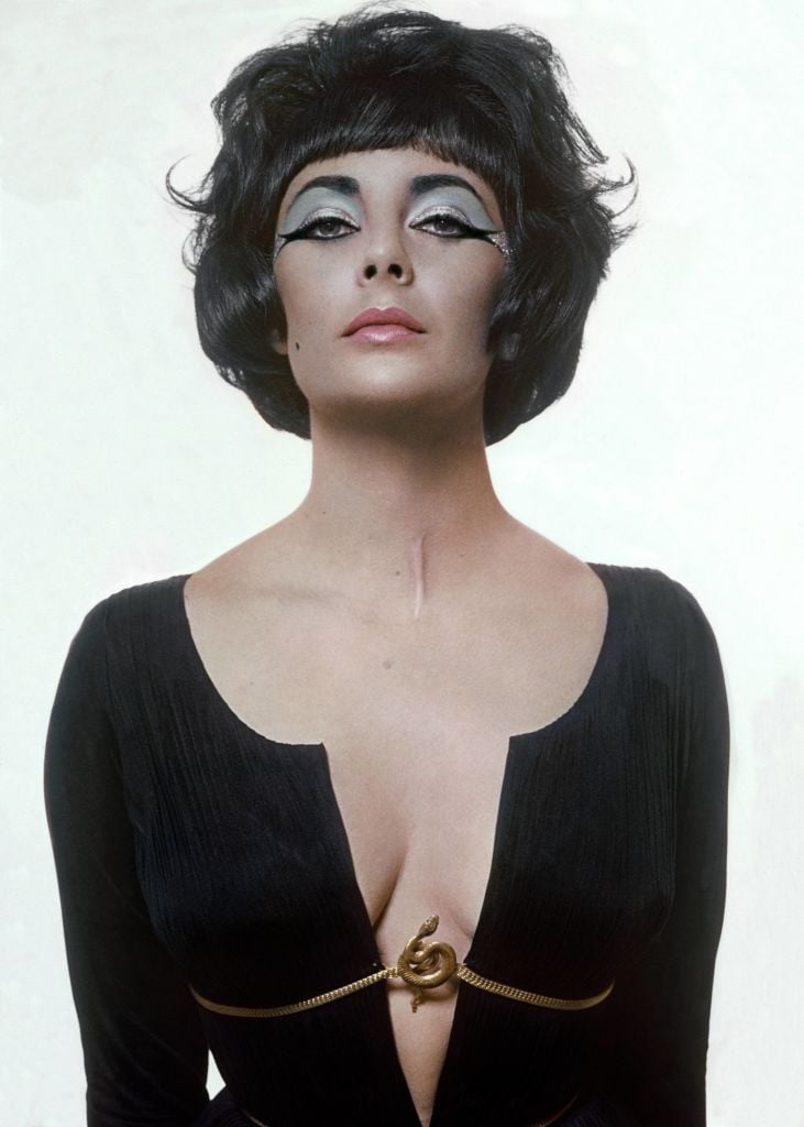 UNITED STATES - JANUARY 15: Elizabeth Taylor dressed as Cleopatra without the head wear, in a black Fortuny pleated dress with a plunging neckline and a serpent clasp defining the empire waist. (Photo by Bert Stern/Conde Nast via Getty Images)