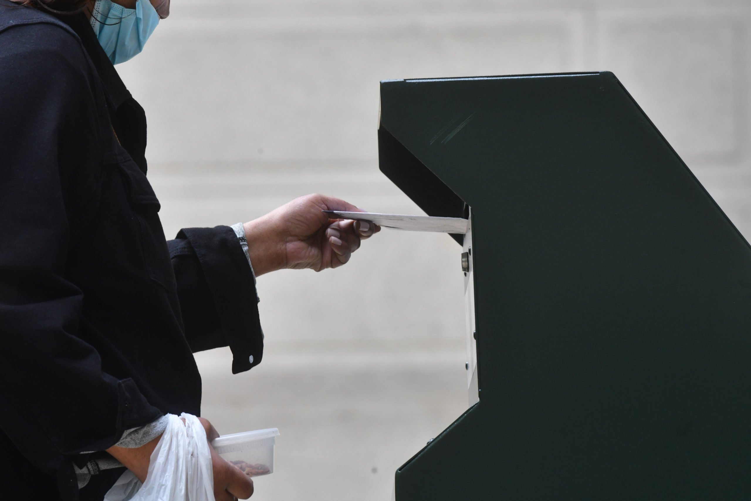 A woman deposits her ballot in an official ballot drop box at the satellite polling station outside Philadelphia City Hall on October 27, 2020 in Philadelphia, Pennsylvania. (Photo by Mark Makela/Getty Images)