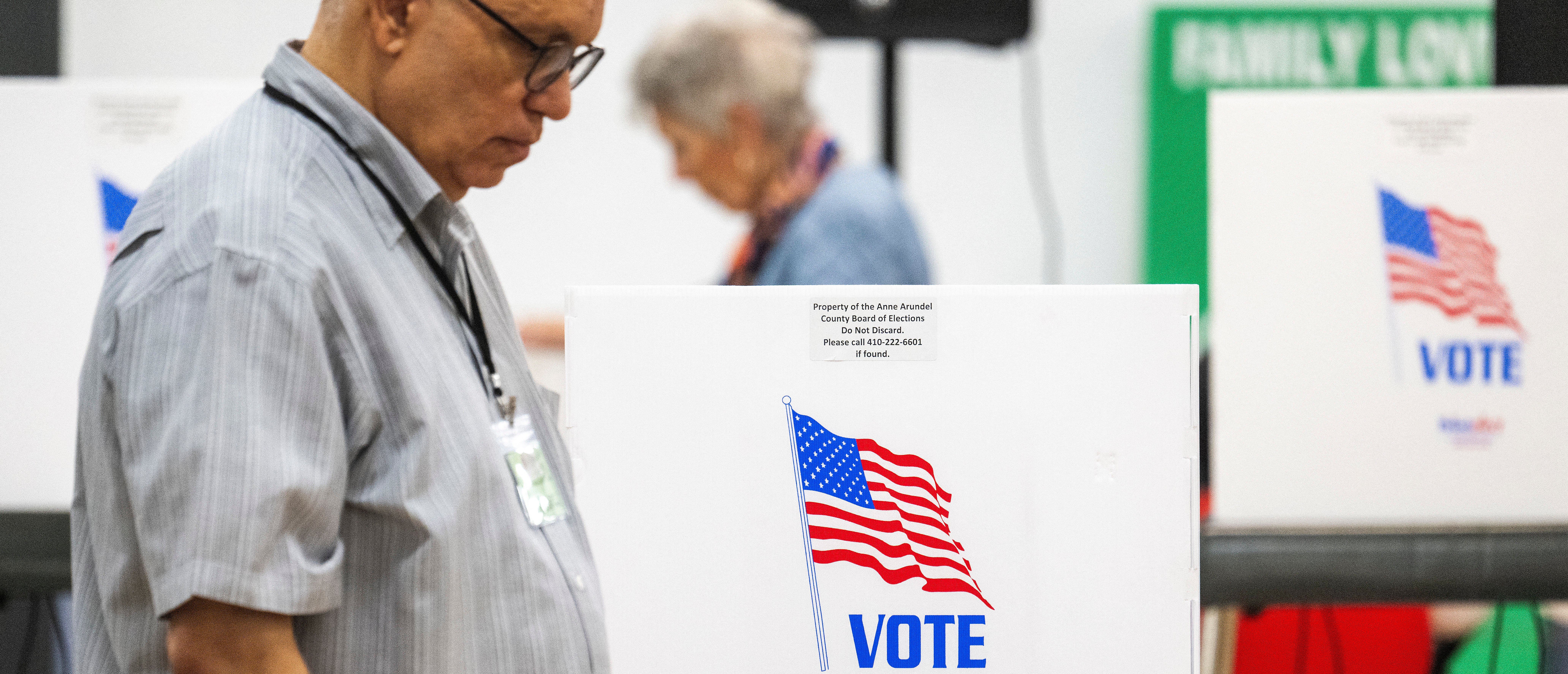 Maryland Board of Elections poll workers pass by empty booths during the Maryland state primary election at a polling station in Annapolis, Maryland, on May 14, 2024. (Photo by Jim WATSON / AFP) (Photo by JIM WATSON/AFP via Getty Images)